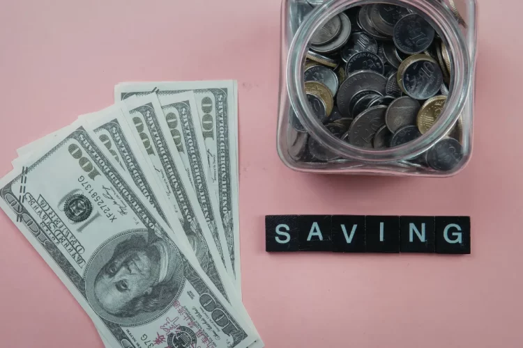 Imagem com dólares espalhados, um pote com moedas e o nome saving