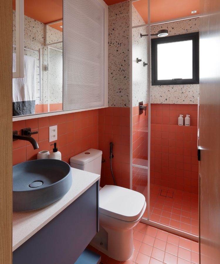 Banheiro em tons de salmão, branco e azul