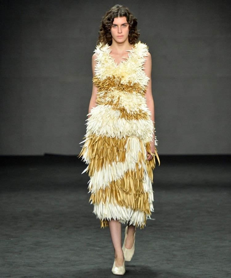 Modelo na passarela usando vestido de plumas, uma das tendências do Rio Fashion Week 2026