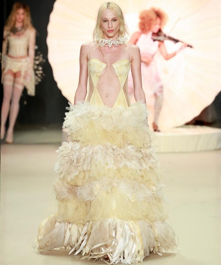 Modelo na passarela usando vestido branco com babados, uma das tendências do Rio Fashion Week 2026