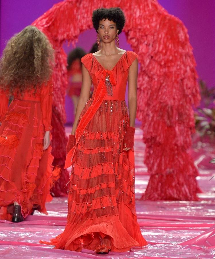 Modelo na passarela usando vestido vermelho com babados, uma das tendências do Rio Fashion Week 2026