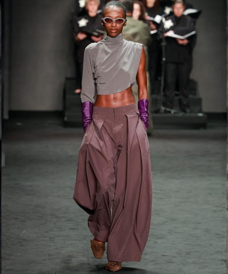 Modelo na passarela usando blusa e calça ampla de alfaiataria, uma das tendências do Rio Fashion Week 2026