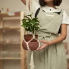 pessoa segurando planta em cachepô pendurado de macramê feito com corda