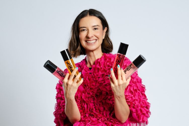 Mulher segurando linha de body splash So Delícia!, marca da Nude Code Beauty