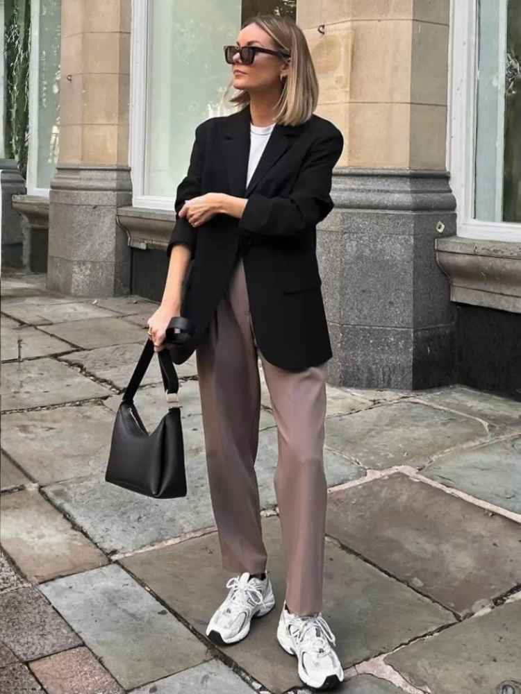 Mulher loira usando look de estilo urbano elegante com tendência de sneakers