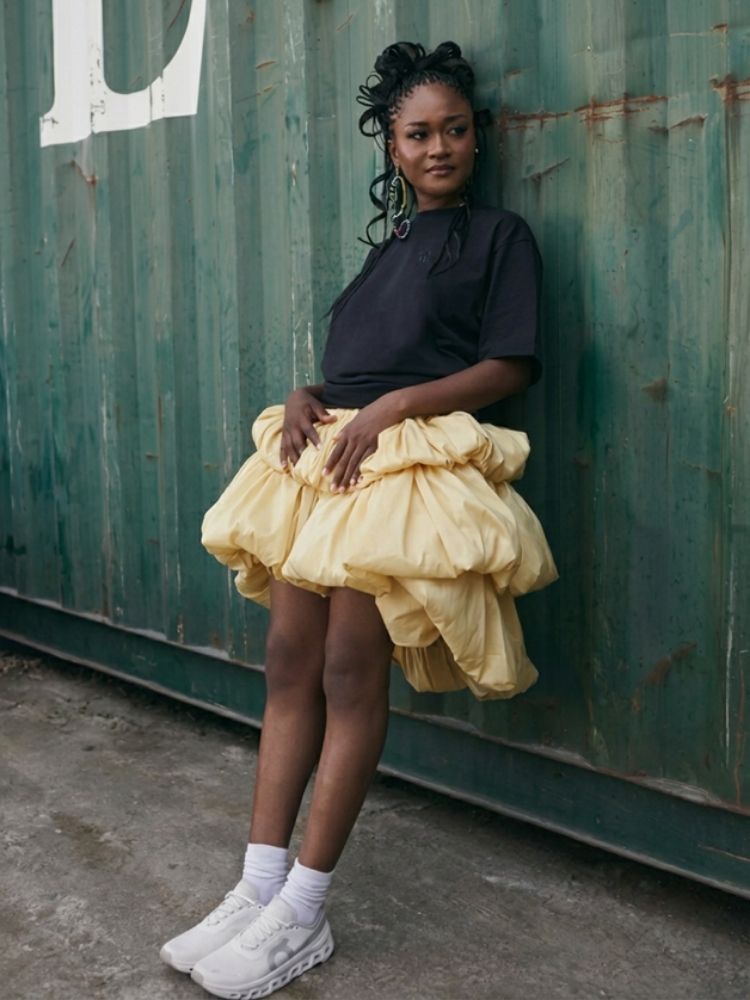 Mulher negra usando tendência de sneakers misturada com peças femininas