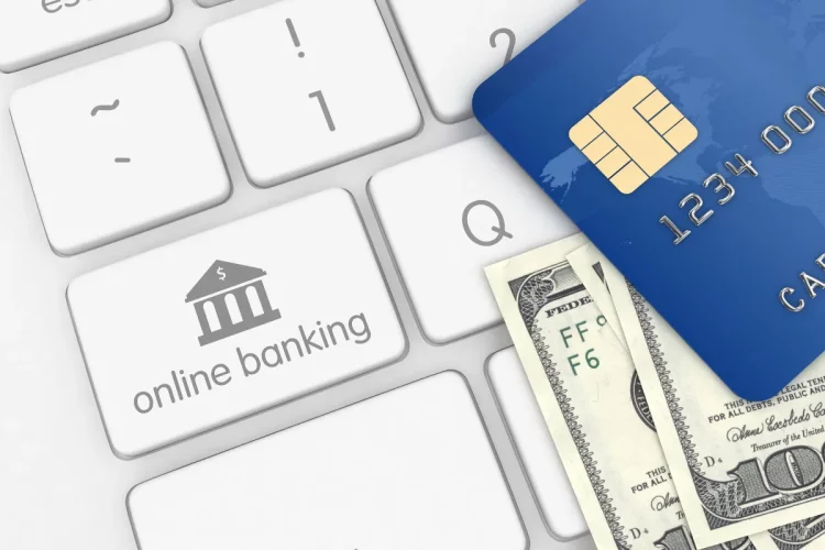 Cartão bancário sobre teclado com símbolo de internet banking ilustrando segurança em empréstimo online.