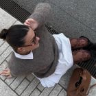 Foto de influencer usando look com meia-calça estampada, vestido branco, suéter cinza e bota preta