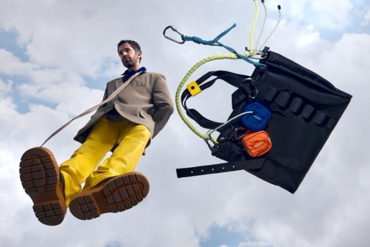 Alexandre Pavão ao lado de bolsa preta da collab com a Pool da Riachuelo