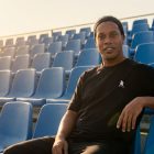Ronaldinho Gaúcho usando camiseta preta oversized de sua marca de roupas