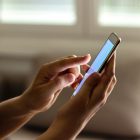Mão de pessoa mexendo no celular para fazer escolha das plataformas de apostas online