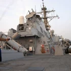 Marinheiro pulando corda com roupa esportiva no convés de um navio, ao ar livre