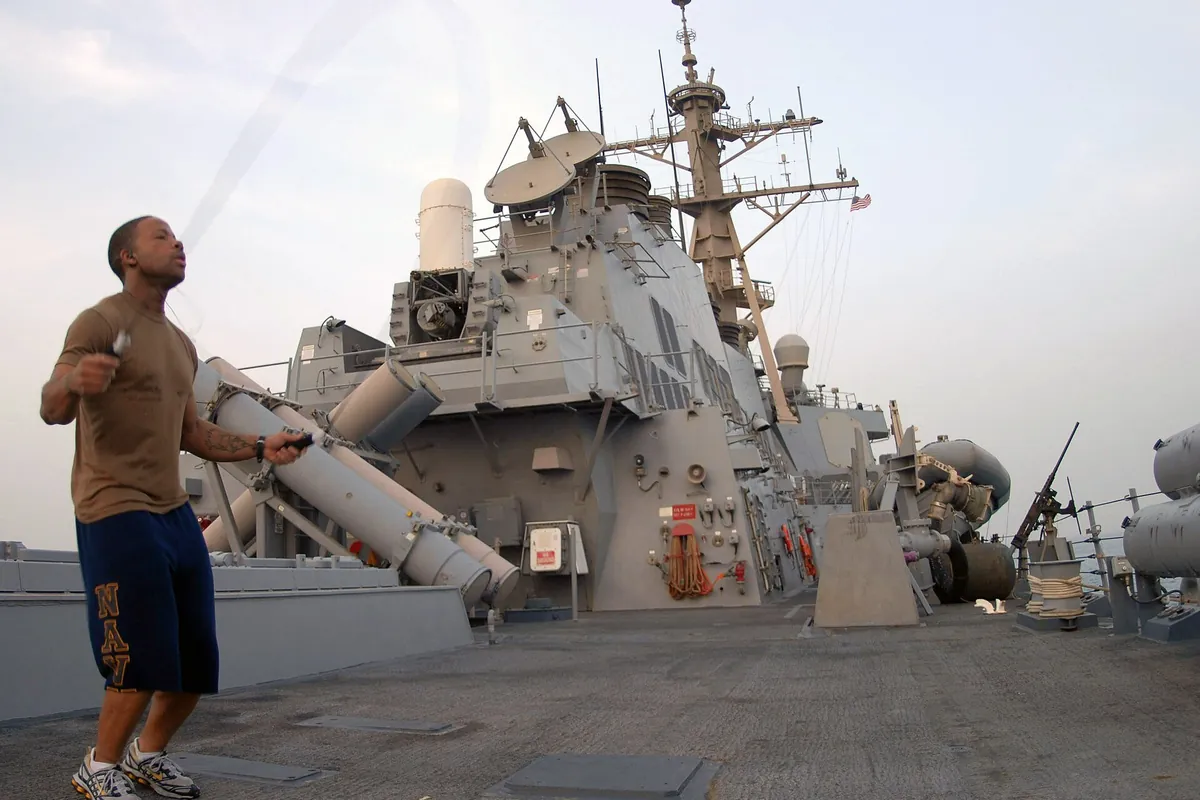 Marinheiro pulando corda com roupa esportiva no convés de um navio, ao ar livre