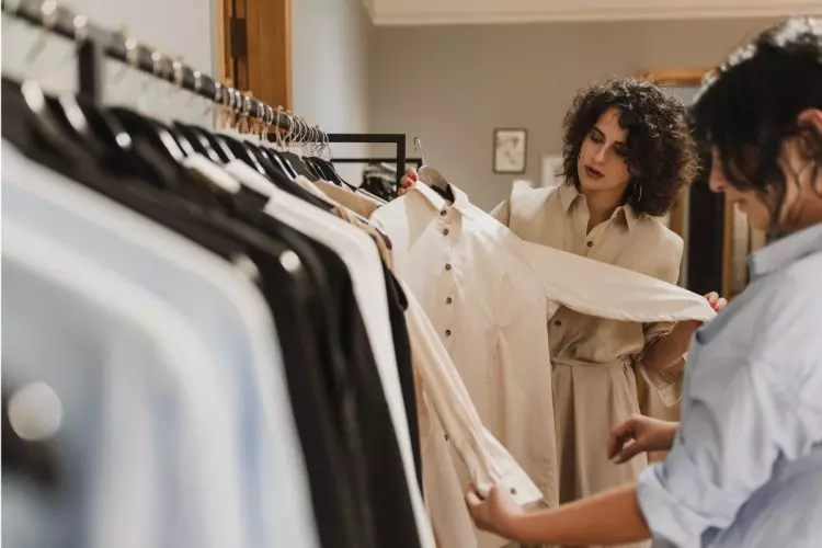 Personal stylist em loja com cliente para montar guarda-roupa versátil
