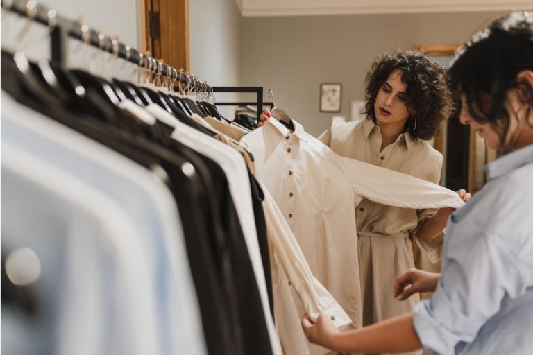 Personal stylist em loja com cliente para montar guarda-roupa versátil