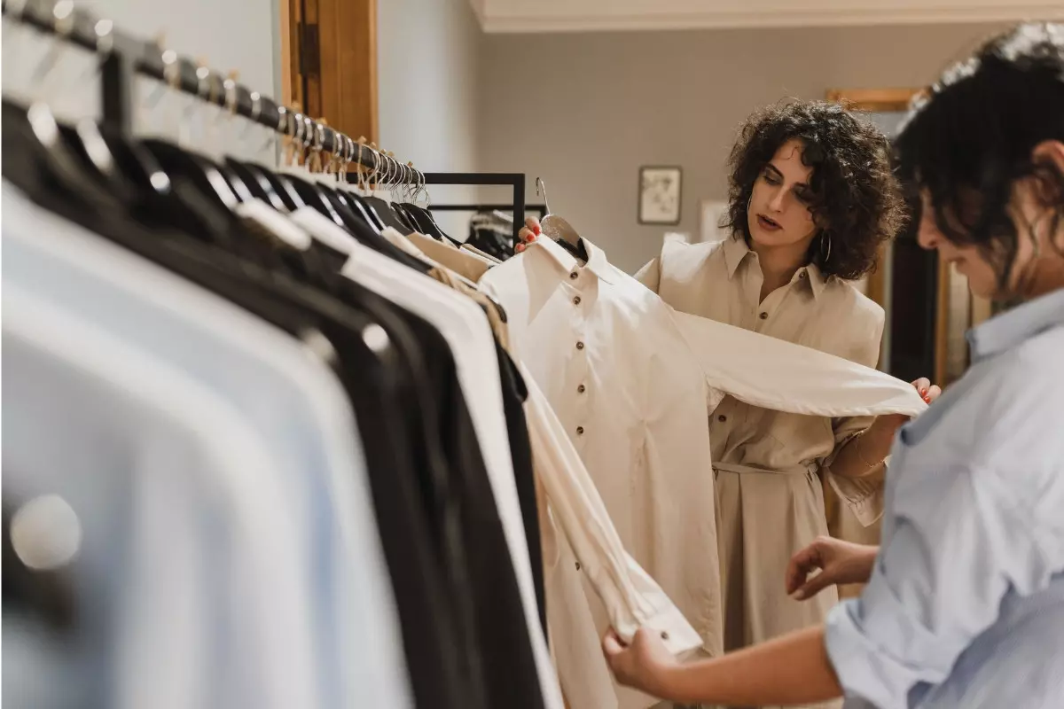 Personal stylist em loja com cliente para montar guarda-roupa versátil